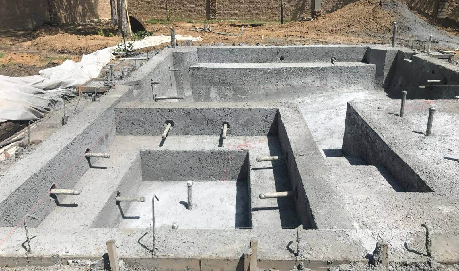 Pool build in progress, concrete caverns with rebar poking through