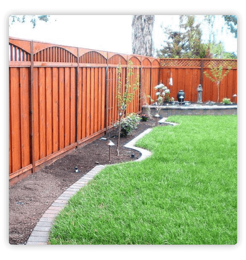 Redwood fence with arches enclosing garden