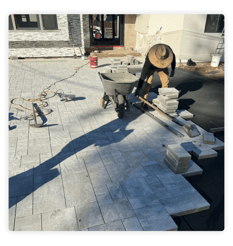 Man laying down bricks to create new walkway.