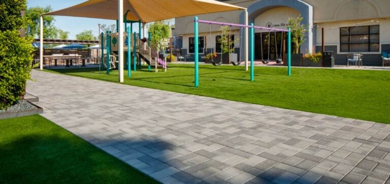 Paved grey and dark grey walkway outside of elementary school.